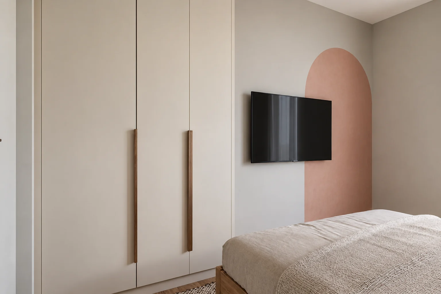 Guest room with a cream built-in wardrobe and a terracotta painted arch behind the TV