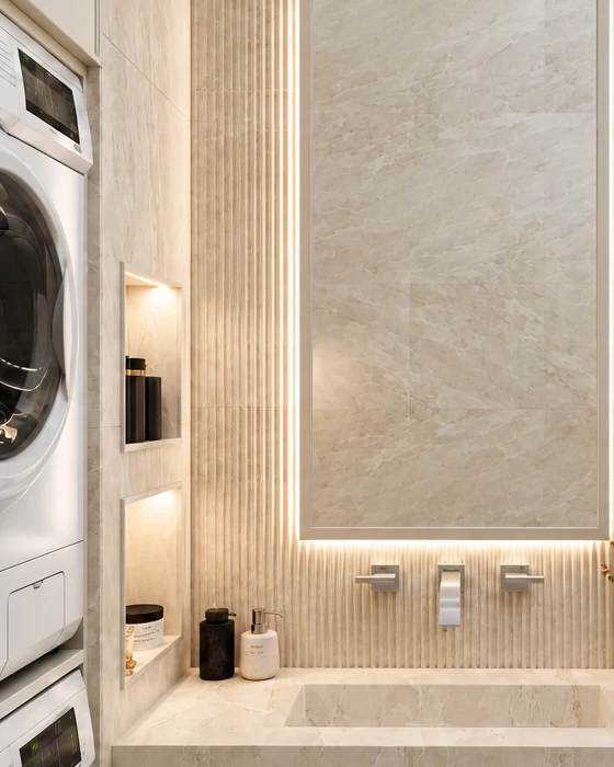 Backlit mirror between fluted wall cladding, with a wall-mounted tap below it and illuminated wall niches and the washer-dryer stack on the left