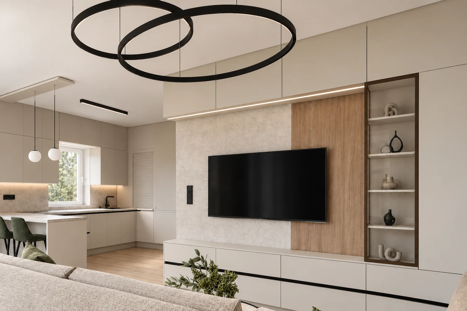 Living room with a TV wall: a light, textured wall surface, a vertical oak panel and a dark-framed glass display cabinet, a pendant light made of two black rings in the foreground, and the kitchen with olive-green bar stools on the left