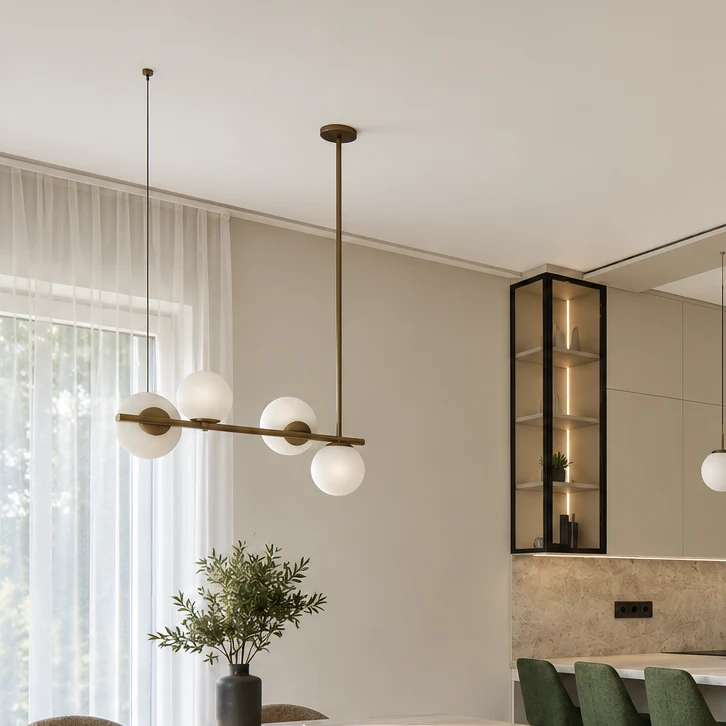 Pendant light with four white globes mounted on a horizontal bar above the dining area, with a sheer curtain and the kitchen's dark-framed display cabinet in the background