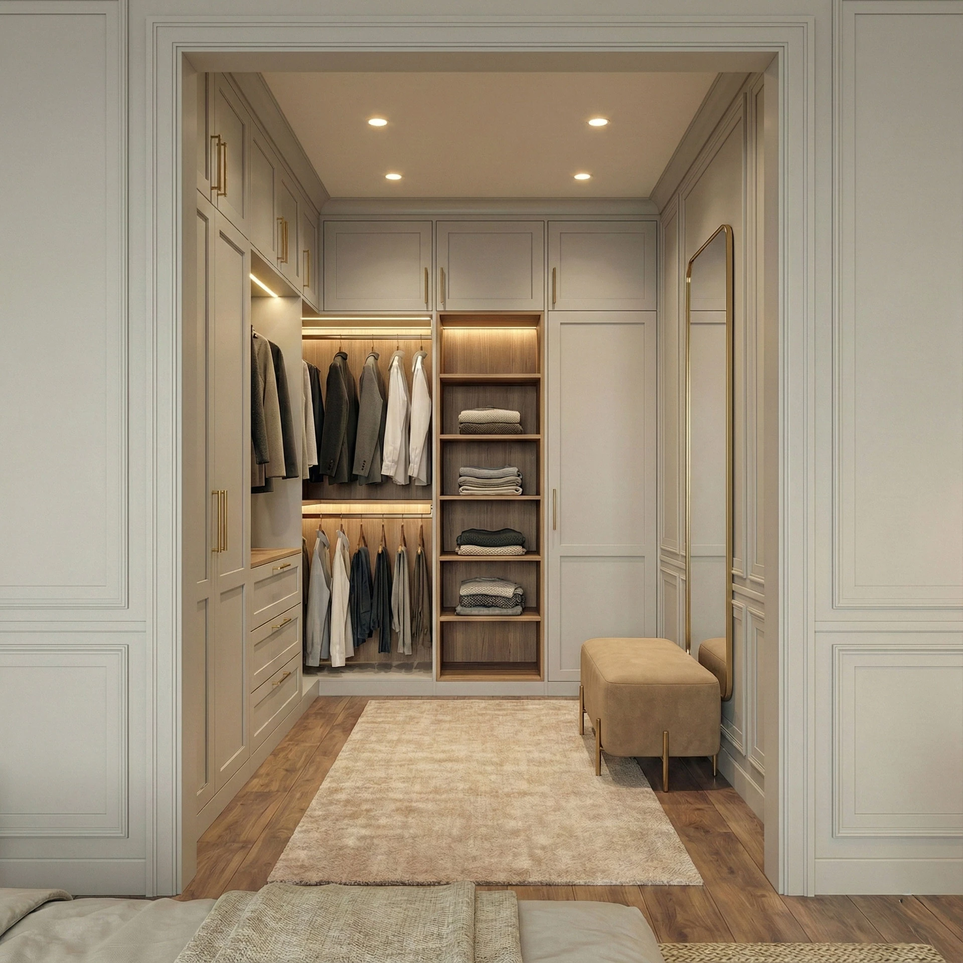 Walk-in wardrobe with painted fronts, lit open shelves, hanging sections, an upholstered bench and a brass-framed mirror