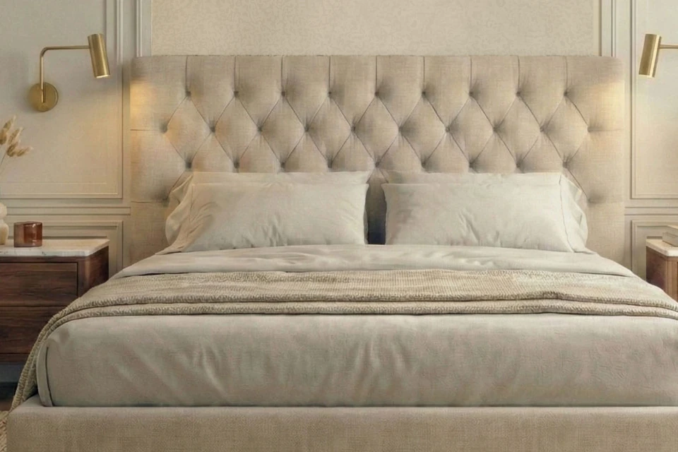 Buttoned upholstered headboard with a brass wall light on each side