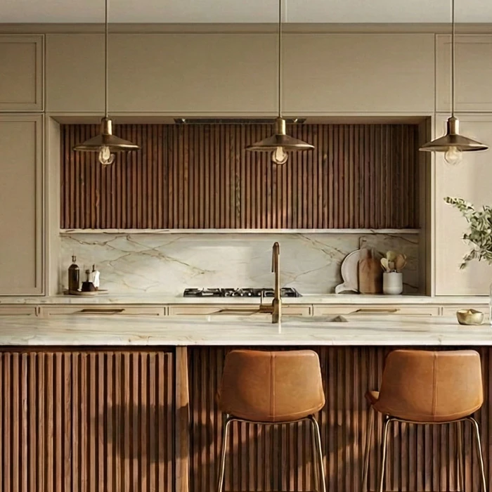 Battened wooden wall panel in the kitchen alcove with three pendant lights in front of it and a marble-patterned back wall below, with the island worktop and two leather bar stools in the foreground