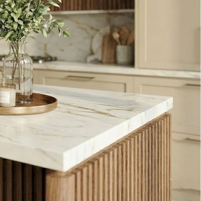 Corner of the kitchen island: a thick, veined marble-effect worktop and vertical wooden battens