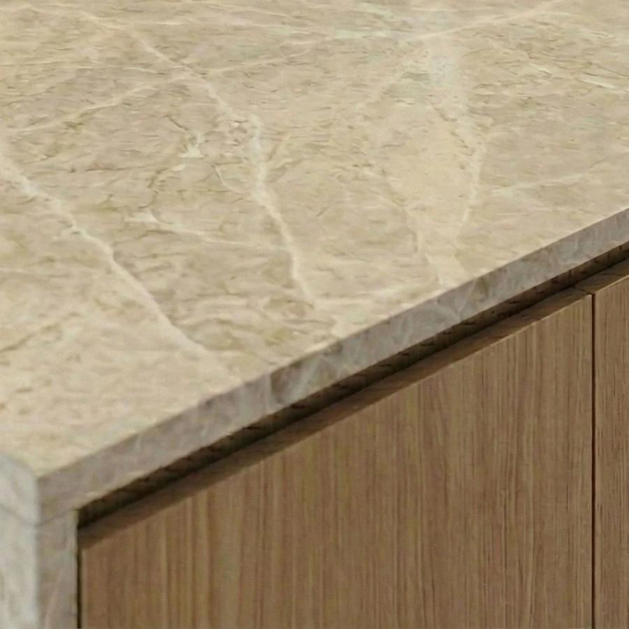 The edge of the kitchen island’s marble-effect worktop, with the wooden front below