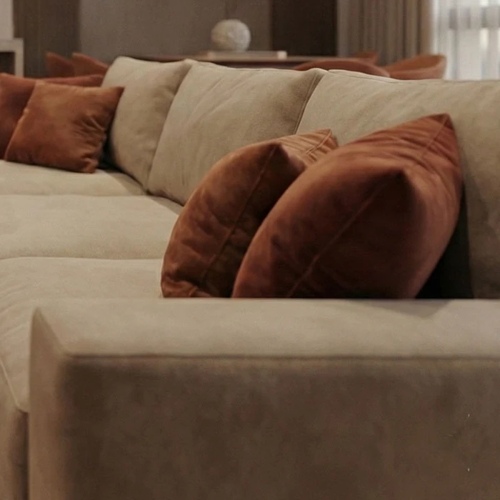 Terracotta velvet cushions on the beige upholstered sofa