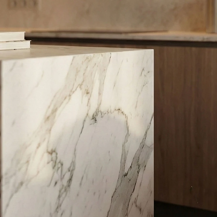 Corner of the marble-effect kitchen island, with wooden base cabinets behind it